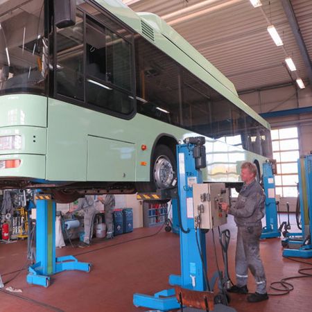 Bus in der Werkstatt zur Reparatur auf der Hebebühne