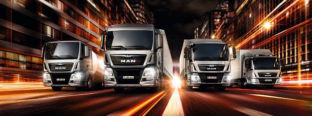 Vier MAN Lkw auf einer Straße bei Nacht