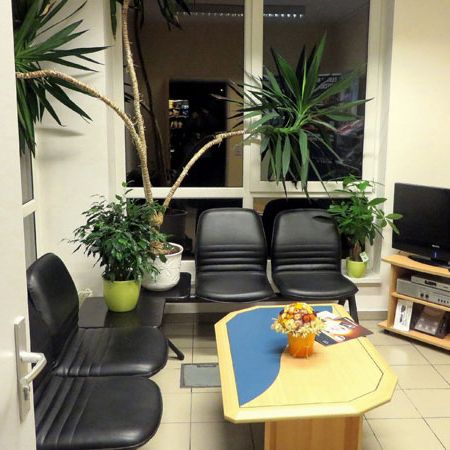 Kundenwarteraum mit Fernseher und schwarzen Lederstühlen